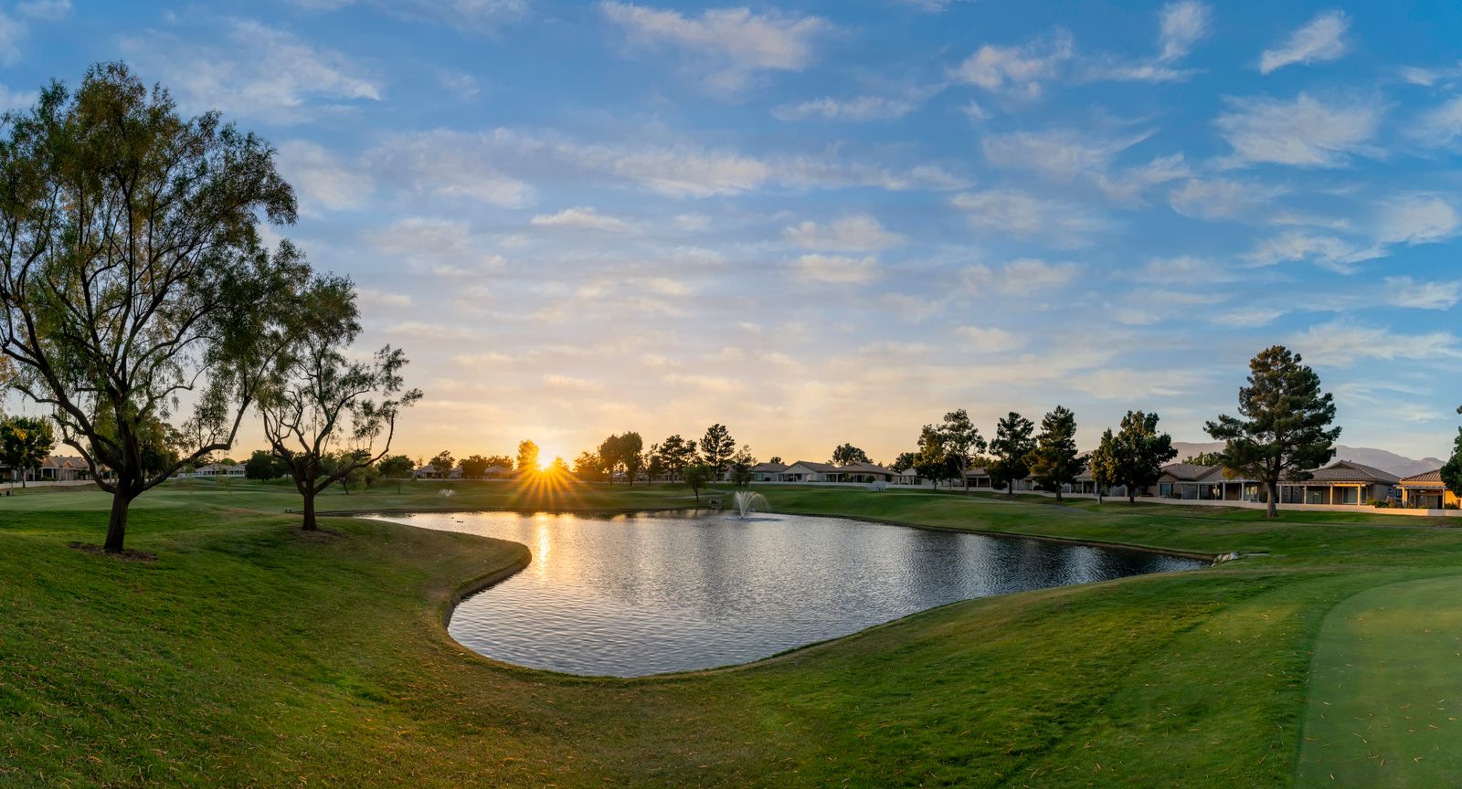 Warm evening light across a golf course and lake